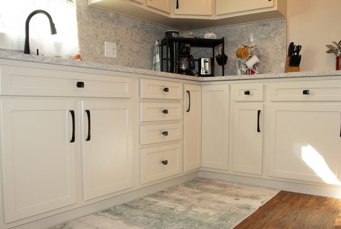 almond kitchen cabinets with black hardware in cottage kitchen